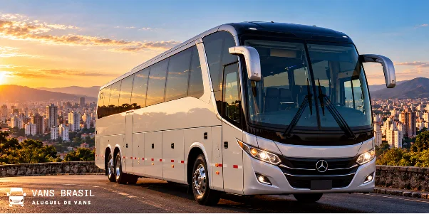 Ônibus rodoviário branco em estrada ao pôr do sol com a cidade de Belo Horizonte ao fundo